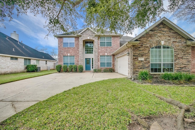 traditional-style home with brick siding, concrete driveway, an attached garage, a front yard, and stone siding