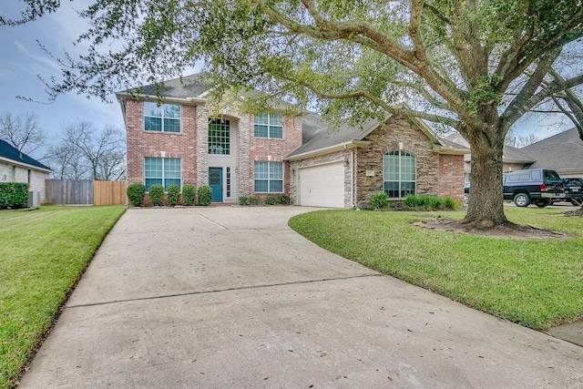 traditional home featuring brick siding, a front yard, fence, a garage, and driveway