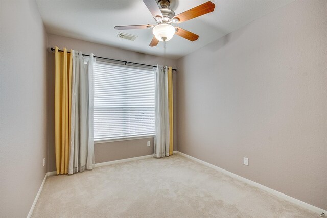 empty room with visible vents, ceiling fan, light carpet, and baseboards