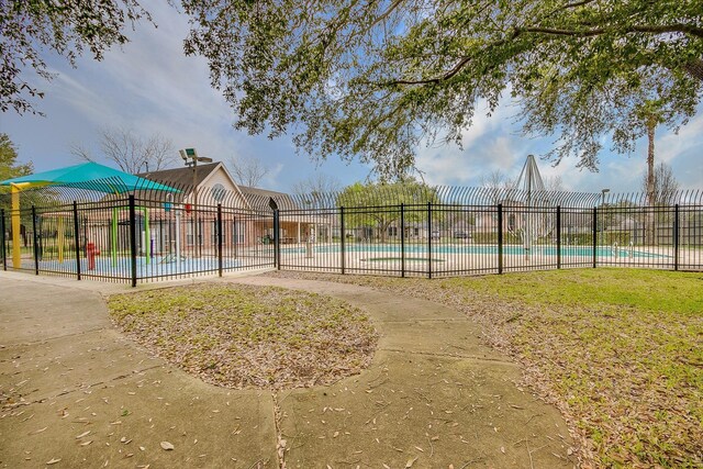 view of property's community featuring a swimming pool and fence