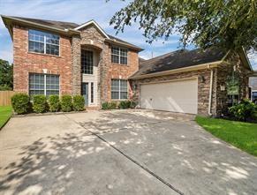 traditional home featuring an attached garage, fence, and concrete driveway