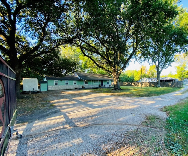 view of front of property with driveway and fence