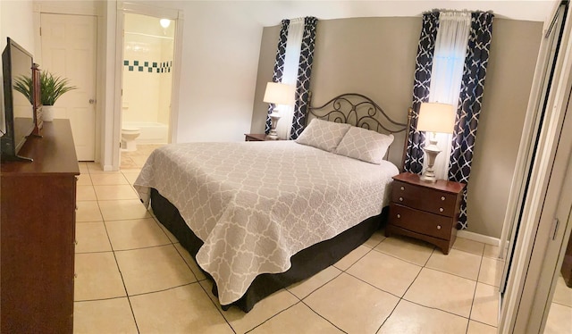 bedroom featuring light tile patterned floors and ensuite bathroom