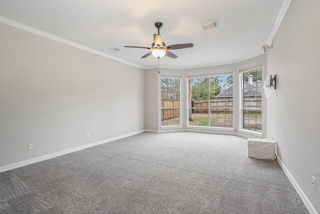 unfurnished room featuring crown molding, carpet flooring, visible vents, and baseboards