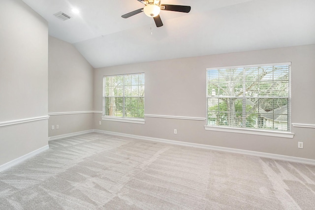 carpeted spare room featuring lofted ceiling, visible vents, and baseboards