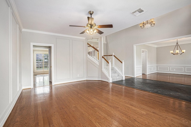 unfurnished living room featuring stairs, wood finished floors, visible vents, and a decorative wall