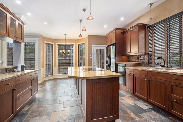 kitchen featuring a sink, black appliances, stone tile flooring, and a center island