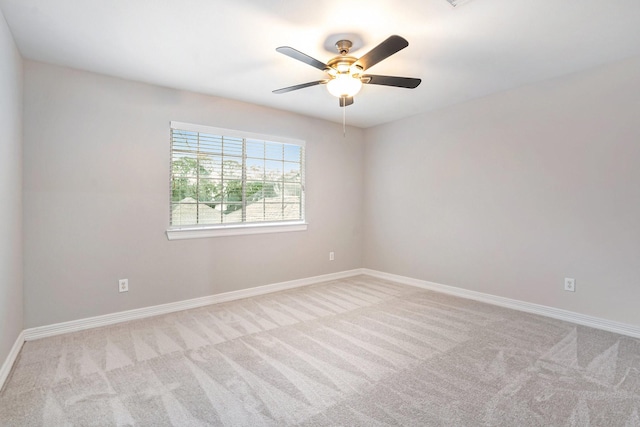 carpeted empty room featuring baseboards and a ceiling fan