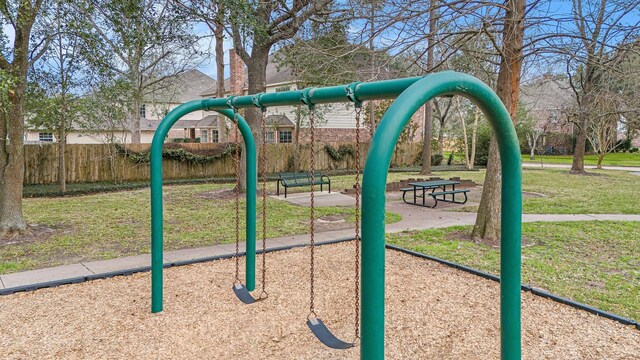 community jungle gym with a yard and fence