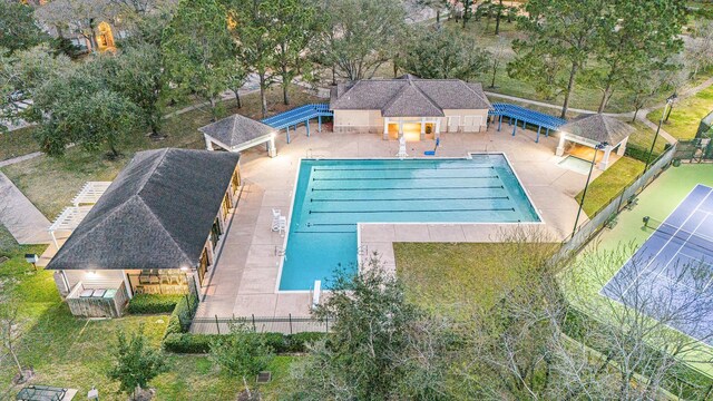 community pool featuring an outbuilding, fence, and a patio