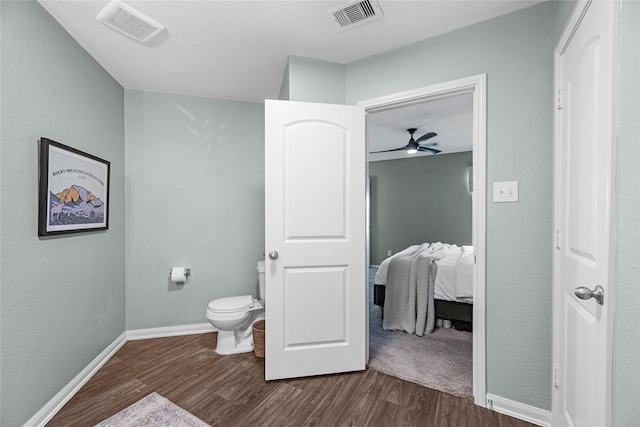 bathroom featuring toilet, baseboards, visible vents, and wood finished floors