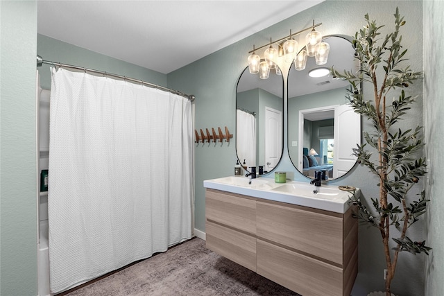 bathroom with visible vents, a sink, and double vanity