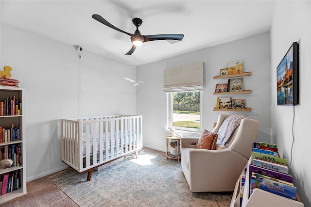 bedroom featuring a ceiling fan, a nursery area, carpet flooring, and baseboards