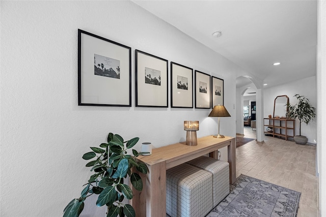 interior space featuring arched walkways, wood finished floors, and recessed lighting