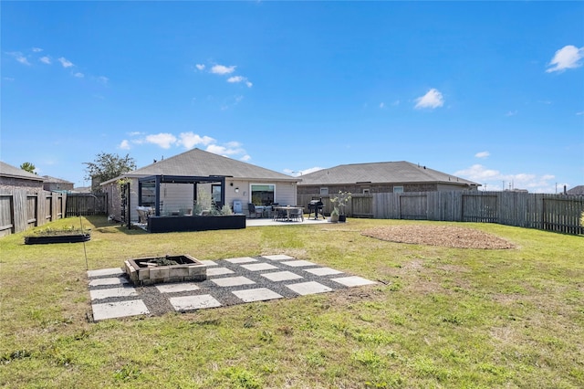 back of property featuring a yard, a patio, a gazebo, an outdoor fire pit, and a fenced backyard