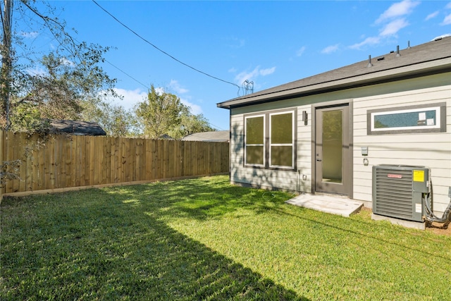 view of yard with central air condition unit and fence