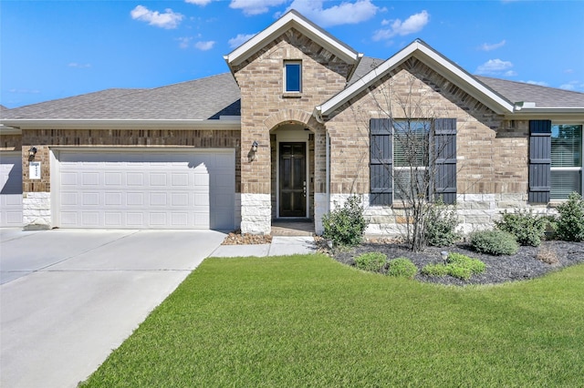 french provincial home with driveway, brick siding, a front yard, and roof with shingles