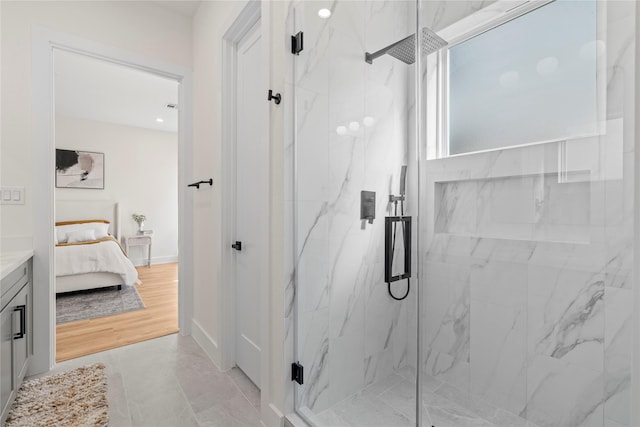 full bathroom featuring a marble finish shower, baseboards, and connected bathroom