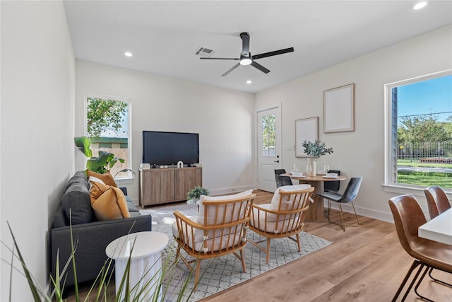 living room featuring baseboards, light wood finished floors, visible vents, and recessed lighting