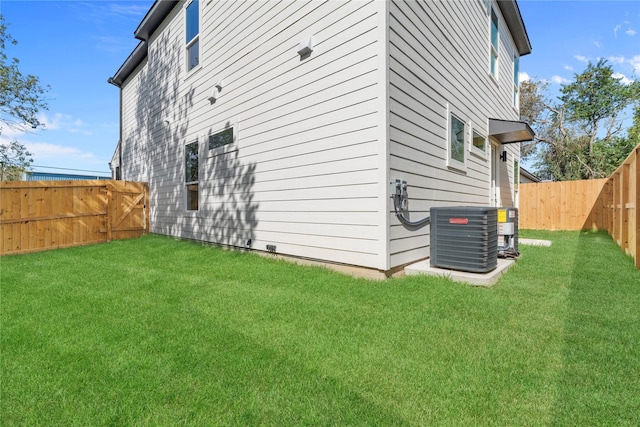 view of property exterior with central AC, a yard, and a fenced backyard