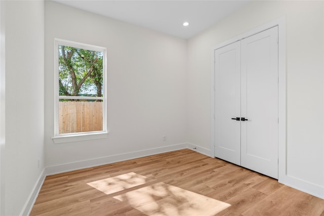 spare room with recessed lighting, light wood finished floors, and baseboards