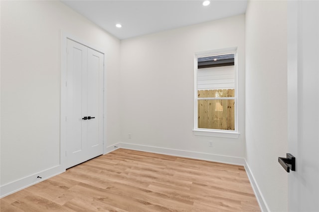 unfurnished room featuring light wood-type flooring, baseboards, and recessed lighting