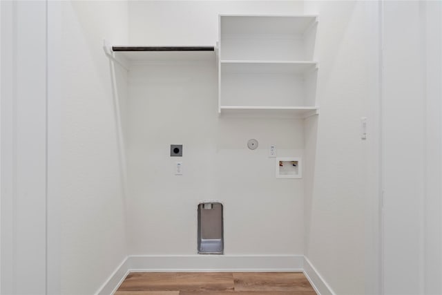 clothes washing area featuring gas dryer hookup, hookup for a washing machine, light wood-style flooring, hookup for an electric dryer, and baseboards