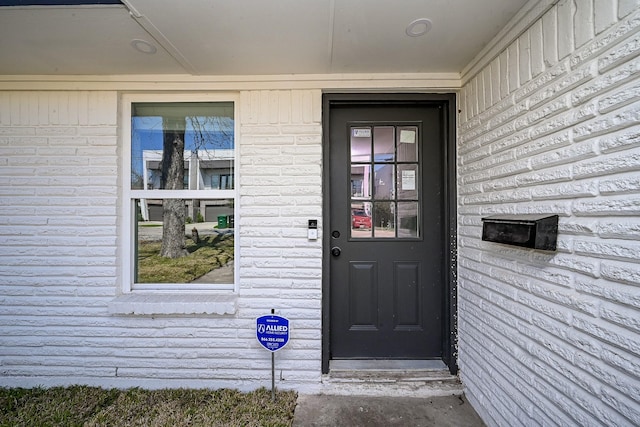 doorway to property with brick siding