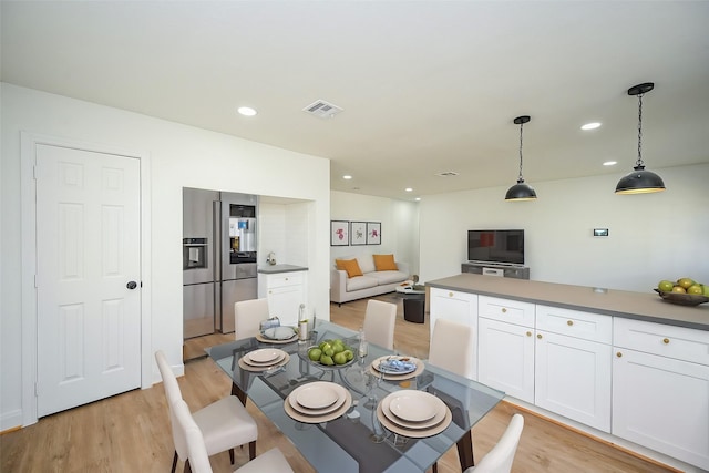 dining area with light wood-style flooring, visible vents, and recessed lighting