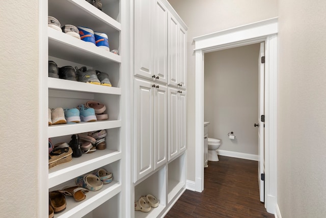 hallway featuring dark wood finished floors and baseboards