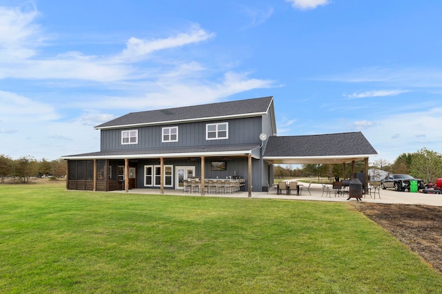 back of house with roof with shingles, outdoor dry bar, a lawn, a sunroom, and a patio area