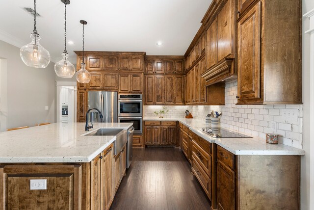 kitchen featuring stainless steel appliances, dark wood-style flooring, a sink, visible vents, and decorative backsplash