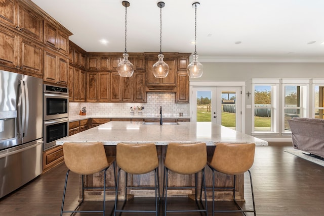 kitchen featuring dark wood-style flooring, a sink, french doors, appliances with stainless steel finishes, and decorative backsplash