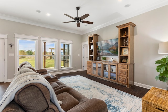 living room featuring dark wood-style floors, crown molding, a ceiling fan, and baseboards