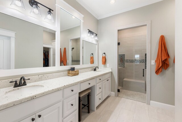 full bathroom with crown molding, a spacious closet, a sink, and a shower stall
