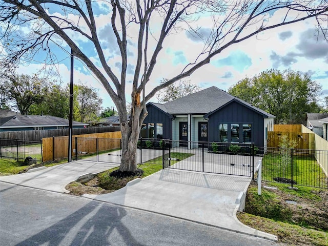 view of front of house featuring a front lawn, board and batten siding, a fenced front yard, and a gate