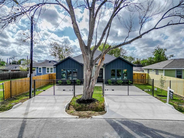 view of front facade with a fenced front yard, a residential view, a gate, and board and batten siding