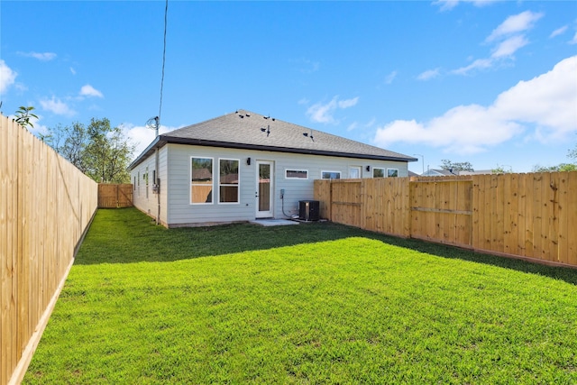 back of house with a yard, a shingled roof, a fenced backyard, and central air condition unit