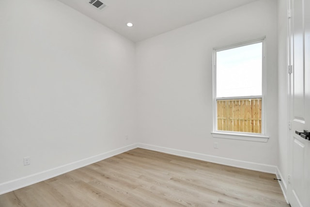 spare room featuring visible vents, light wood finished floors, and baseboards