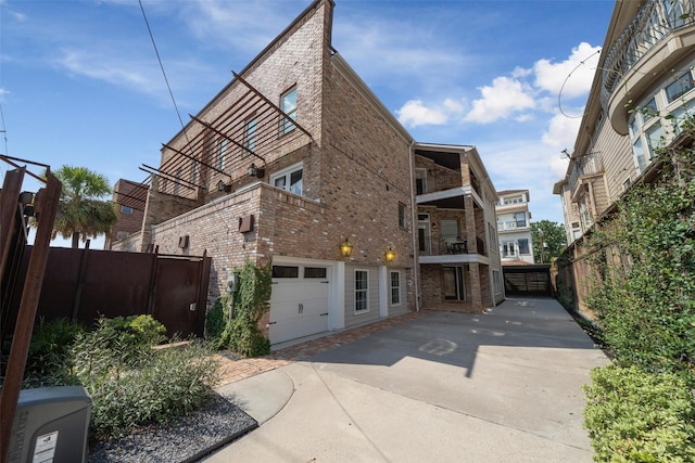 exterior space with an attached garage, fence, and brick siding