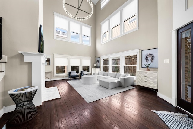 living area with hardwood / wood-style flooring, a high ceiling, and baseboards