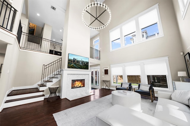 living room featuring a healthy amount of sunlight, stairs, visible vents, and wood finished floors