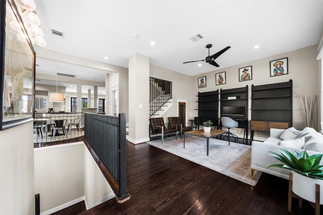 living room with ceiling fan, wood finished floors, and visible vents