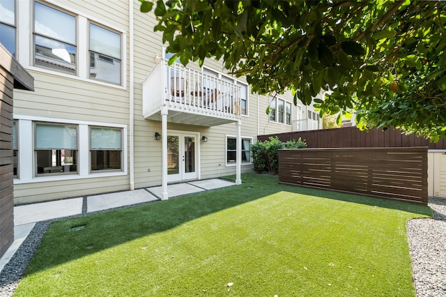 view of yard with a patio, french doors, fence, and a balcony