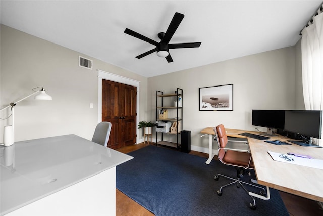 office space featuring visible vents, ceiling fan, baseboards, and wood finished floors