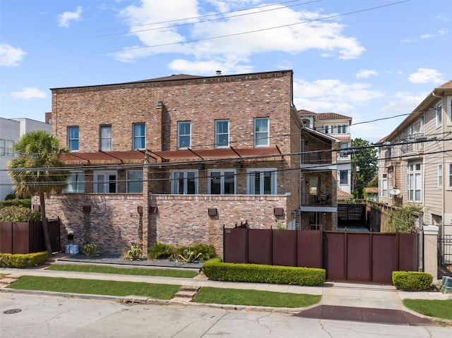 view of front facade with brick siding and fence