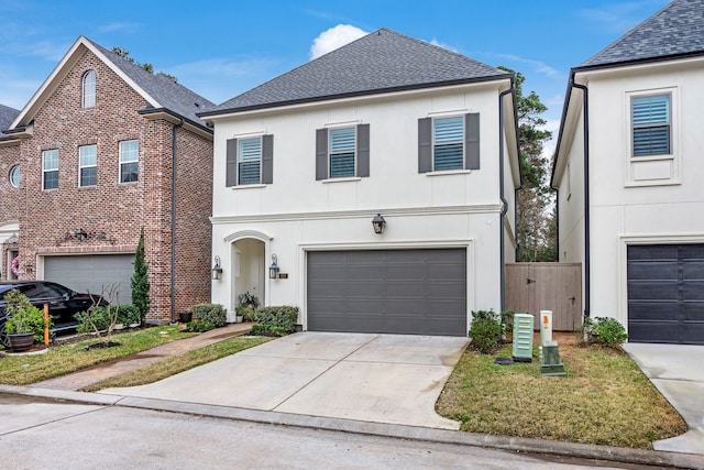 traditional home featuring a garage, concrete driveway, a shingled roof, and stucco siding