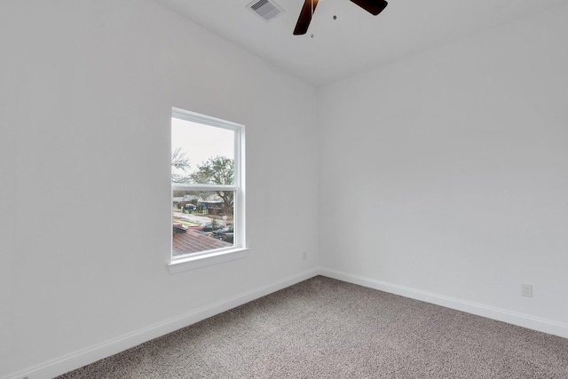 empty room with carpet, visible vents, ceiling fan, and baseboards