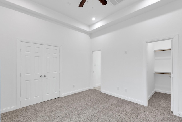 unfurnished bedroom featuring recessed lighting, carpet floors, a towering ceiling, visible vents, and baseboards