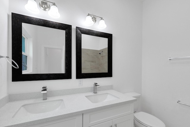 full bathroom featuring toilet, double vanity, a shower, and a sink